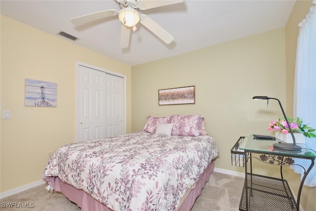 bedroom featuring light colored carpet, a closet, and ceiling fan