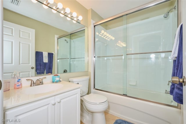 full bathroom with tile patterned floors, shower / bath combination with glass door, vanity, and toilet