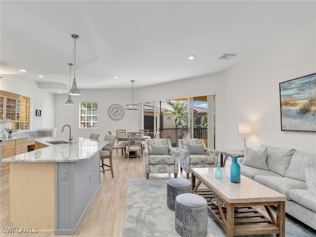 living room with sink and light hardwood / wood-style flooring