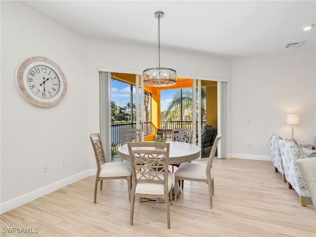 dining space featuring a notable chandelier and light hardwood / wood-style floors