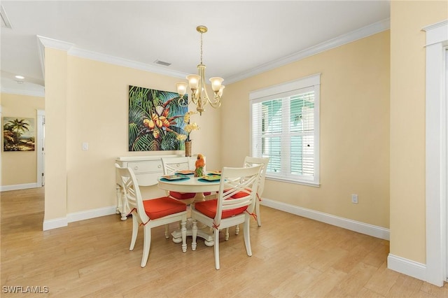 dining space with light hardwood / wood-style floors, a notable chandelier, and ornamental molding