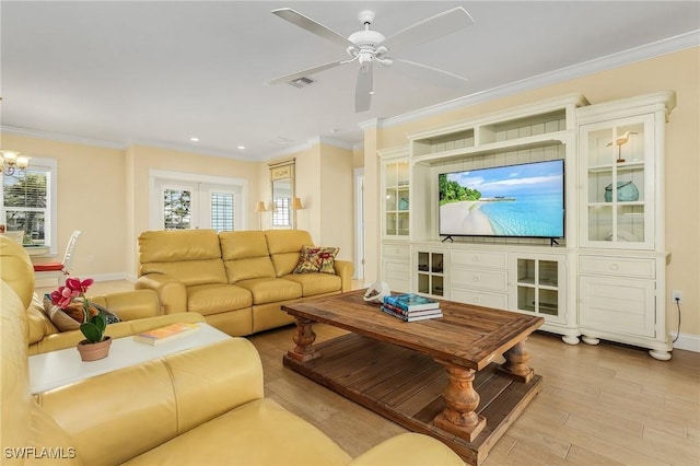 living room with crown molding, a wealth of natural light, and light hardwood / wood-style flooring