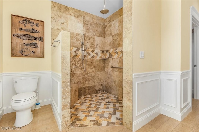 bathroom featuring a tile shower and toilet