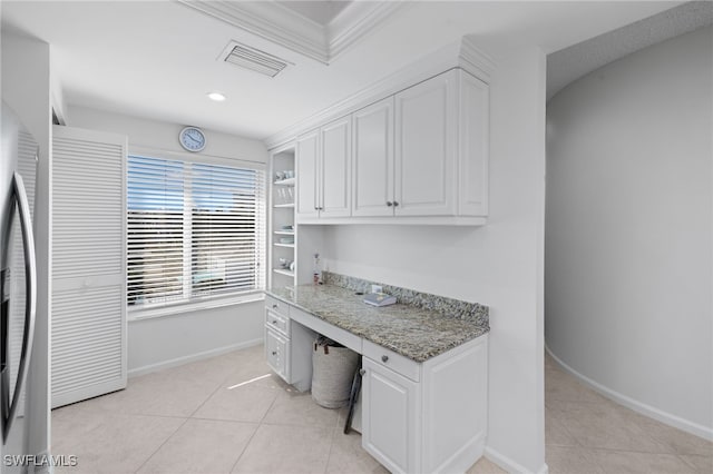 interior space with built in features, built in desk, and ornamental molding