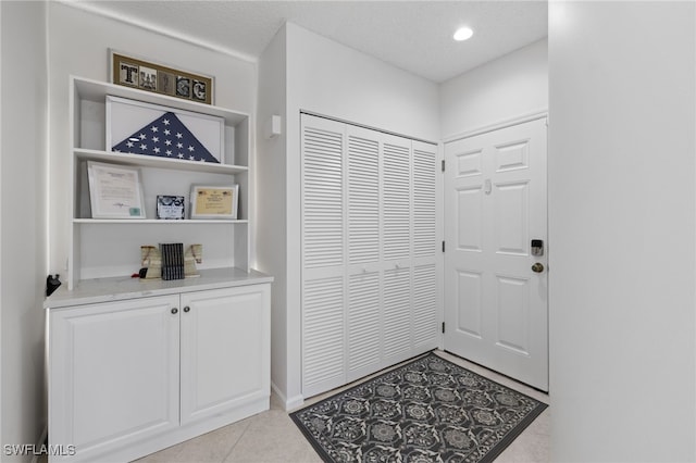 entrance foyer with light tile patterned floors and a textured ceiling