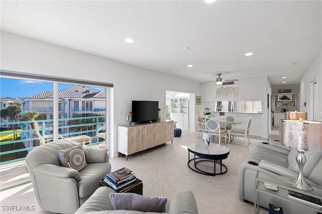 tiled living room featuring ceiling fan and a textured ceiling