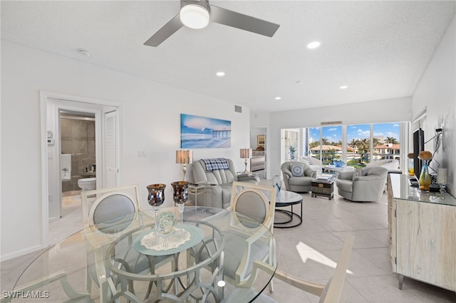 dining space featuring a textured ceiling, ceiling fan, and light tile patterned flooring