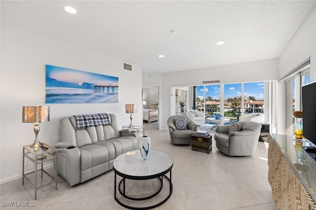 tiled living room featuring a textured ceiling