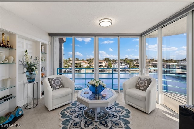 interior space with a water view, a wall of windows, and a textured ceiling