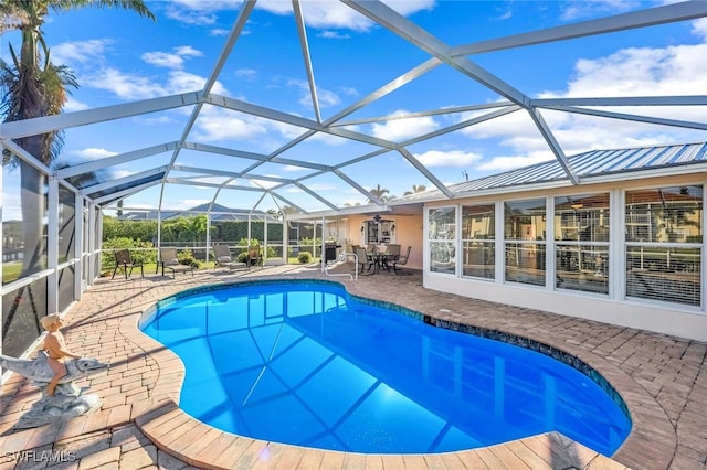 view of swimming pool with glass enclosure and a patio area