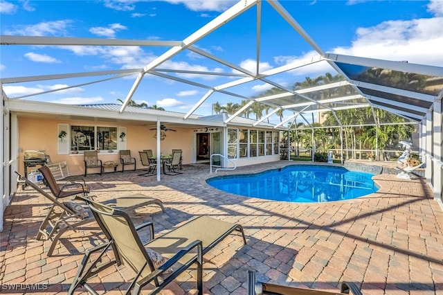 view of pool featuring a sunroom, glass enclosure, ceiling fan, and a patio area