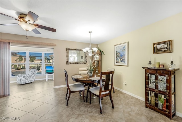 tiled dining space featuring ceiling fan with notable chandelier