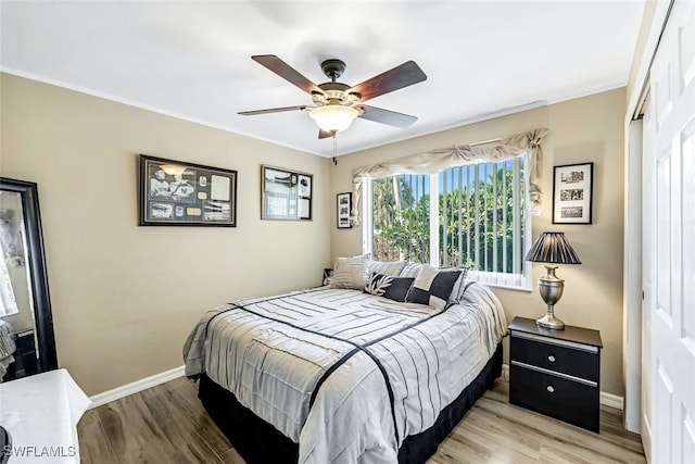 bedroom with light hardwood / wood-style flooring, ceiling fan, and crown molding