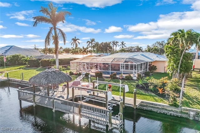 view of dock featuring a water view, a lanai, and a lawn