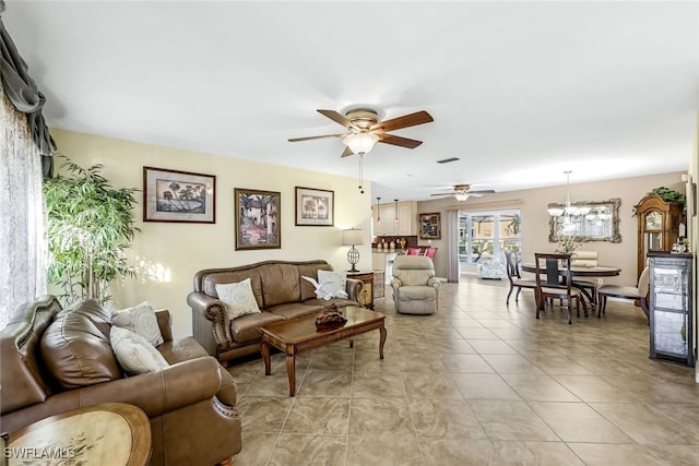 living room featuring ceiling fan with notable chandelier and light tile patterned floors