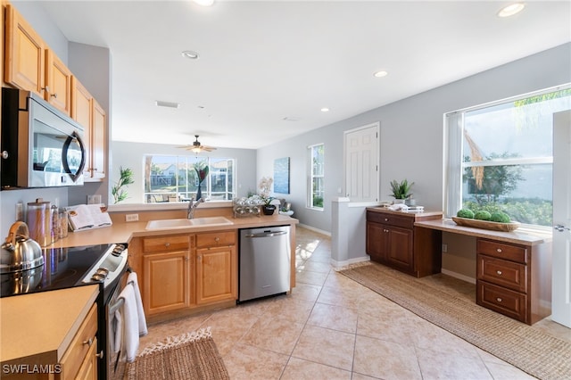 kitchen featuring appliances with stainless steel finishes, light tile patterned floors, ceiling fan, and sink