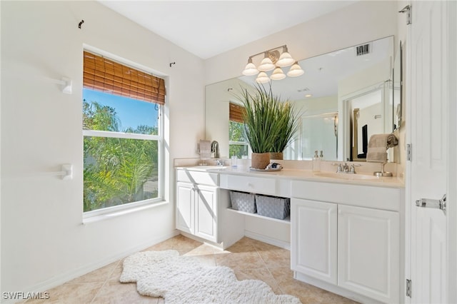 bathroom with tile patterned floors, vanity, and a healthy amount of sunlight