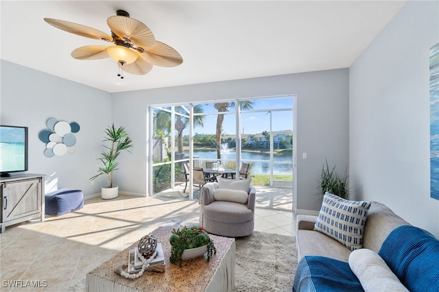 tiled living room with a water view and ceiling fan