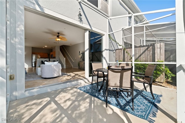 view of patio with glass enclosure and ceiling fan