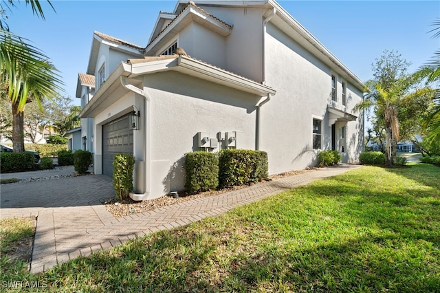 view of home's exterior with a garage and a lawn