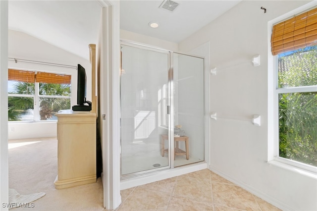 bathroom with a wealth of natural light, a shower with shower door, and vaulted ceiling