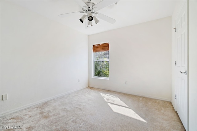 spare room featuring light carpet and ceiling fan