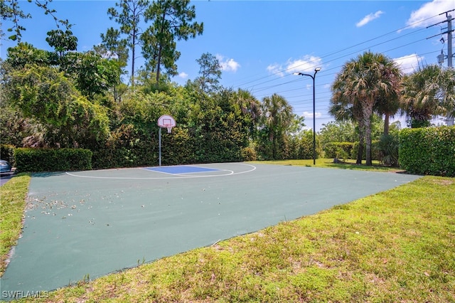 view of sport court with a lawn