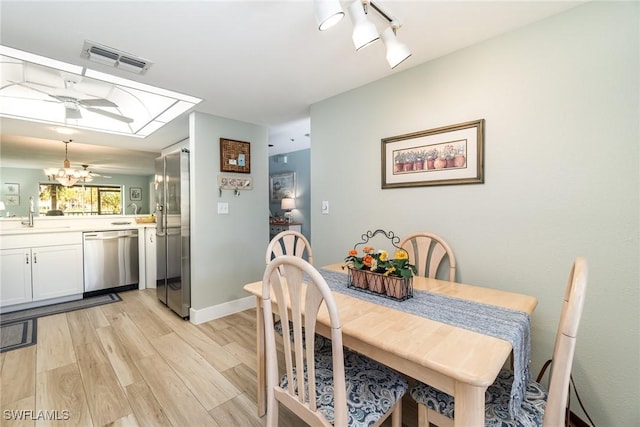 dining room with ceiling fan, light hardwood / wood-style floors, and sink