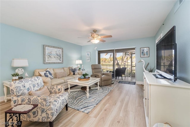 living room featuring ceiling fan and light hardwood / wood-style flooring