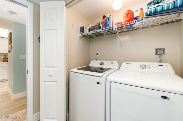 laundry room with washer and dryer and light hardwood / wood-style floors