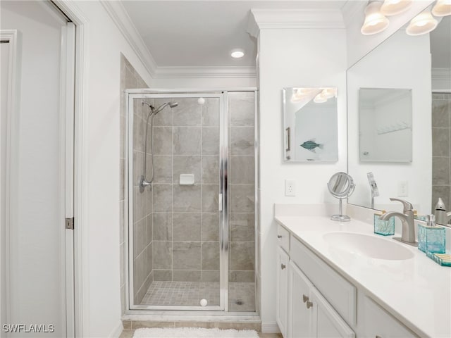 bathroom featuring a shower with door, vanity, and ornamental molding