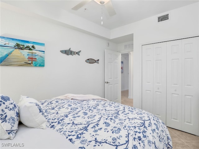 tiled bedroom featuring ceiling fan and a closet