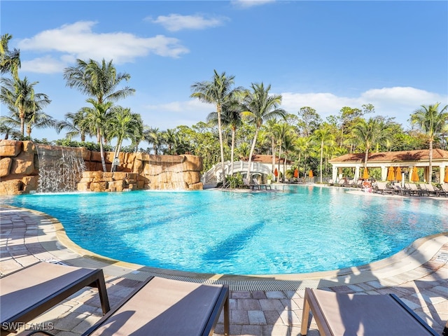 view of swimming pool with pool water feature and a patio area