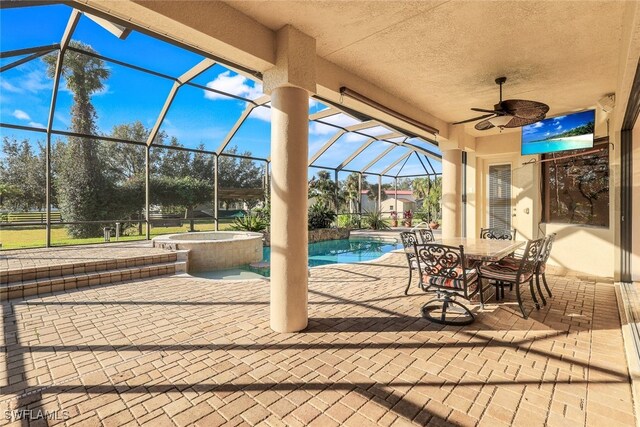 view of patio featuring glass enclosure, ceiling fan, and a pool with hot tub