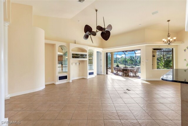 unfurnished living room with ceiling fan with notable chandelier, light tile patterned floors, and high vaulted ceiling