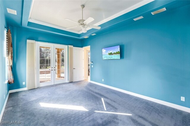 carpeted empty room featuring french doors, a tray ceiling, ceiling fan, and crown molding