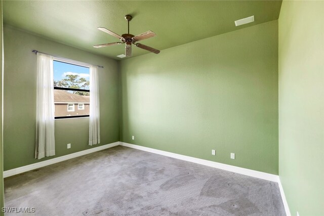 carpeted spare room with ceiling fan