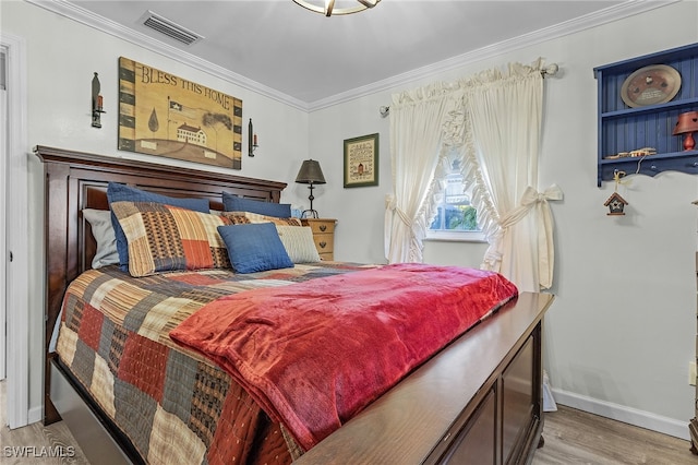 bedroom with light hardwood / wood-style floors and crown molding