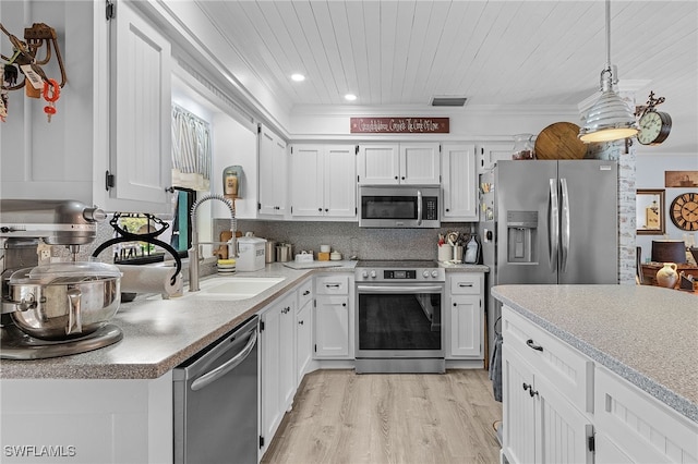 kitchen featuring white cabinetry, light hardwood / wood-style flooring, pendant lighting, and appliances with stainless steel finishes