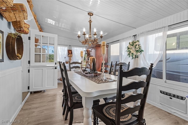 dining space with a chandelier, light hardwood / wood-style flooring, and wood ceiling