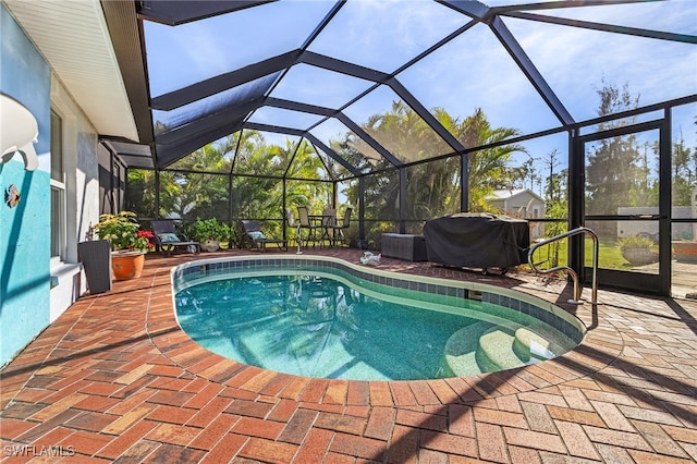 view of swimming pool featuring glass enclosure, a grill, and a patio