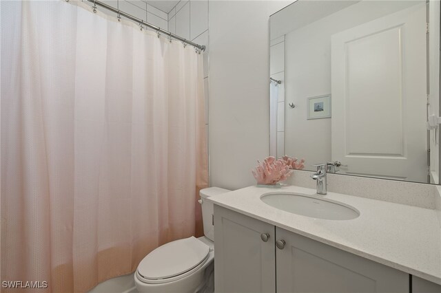 bathroom with vanity, toilet, and curtained shower