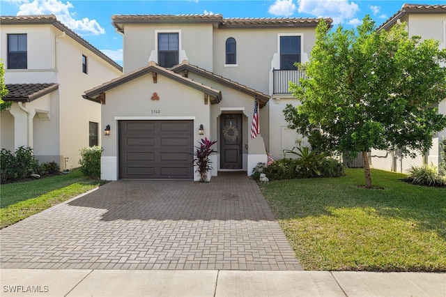 mediterranean / spanish-style house with a balcony, a front lawn, and a garage