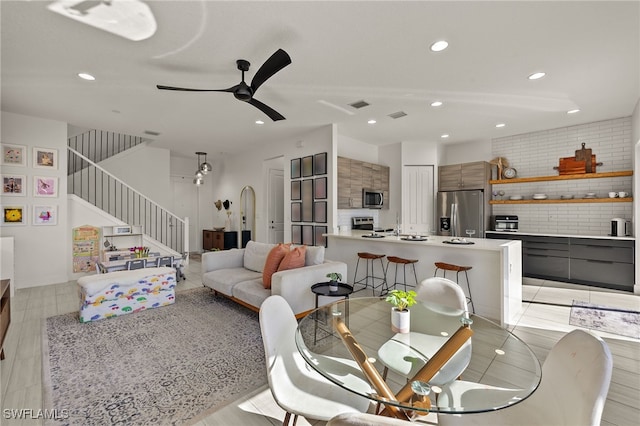 living room featuring ceiling fan and light hardwood / wood-style floors