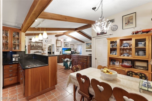 kitchen with an inviting chandelier, lofted ceiling with beams, a kitchen island, decorative light fixtures, and kitchen peninsula