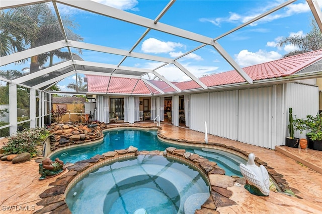 view of pool with an in ground hot tub and glass enclosure