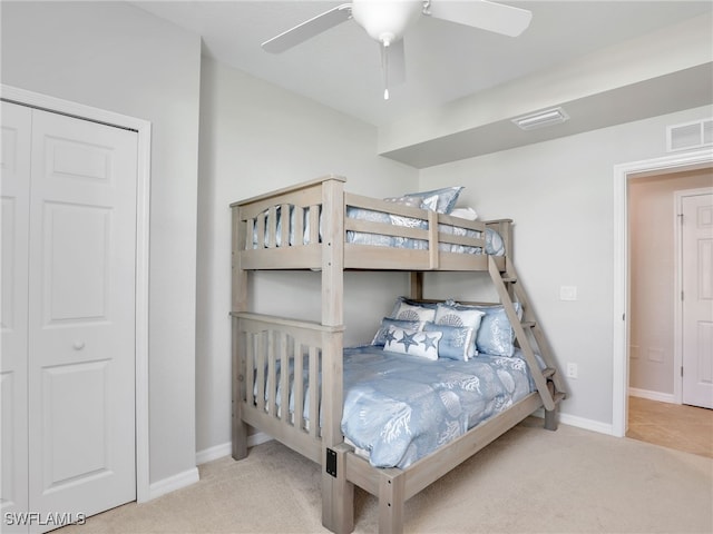 bedroom with a closet, light colored carpet, and ceiling fan