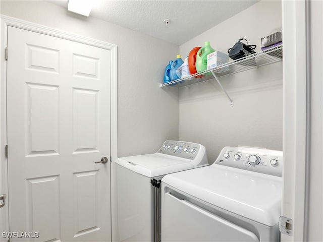 washroom with washer and clothes dryer and a textured ceiling