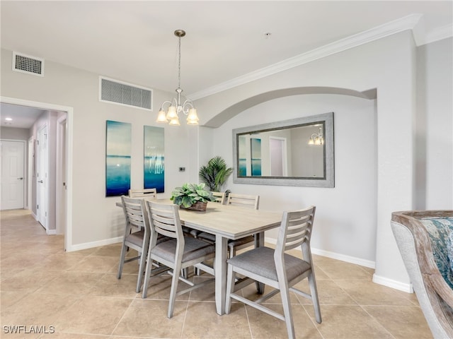 tiled dining room with ornamental molding and a chandelier