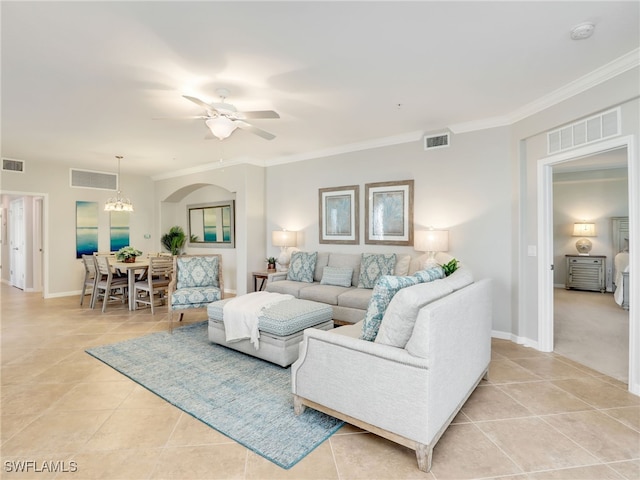 living room with ceiling fan with notable chandelier, light tile patterned floors, and crown molding